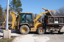 Street Maintenance Equipment - Tractor loading into a dumpster truck